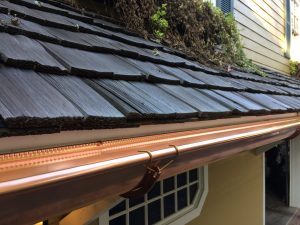 half round copper gutter installed on a wood shake roof