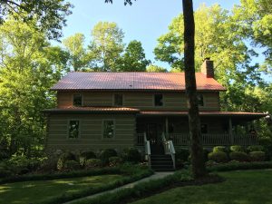 log cabin with red metal roof and 7 inch gutters from gutter guards direct