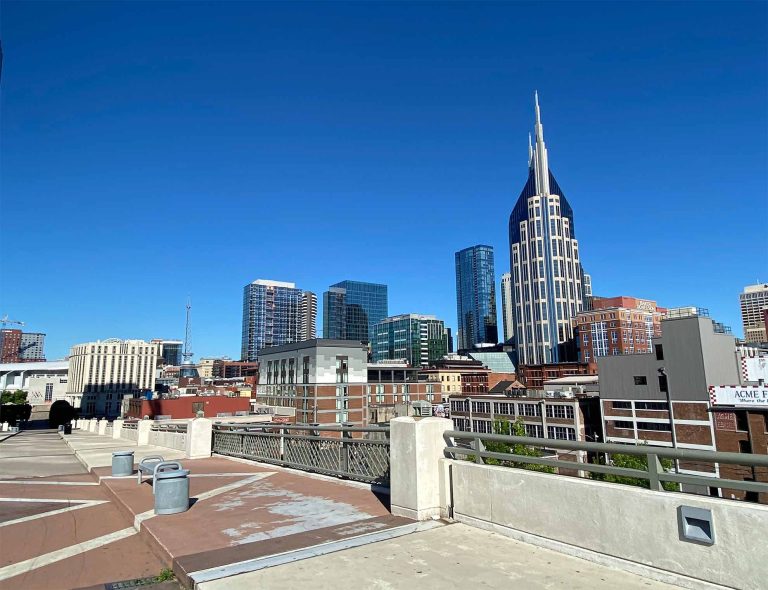 downtown nashville looking from the east on a walking bridge, featuring the batman building