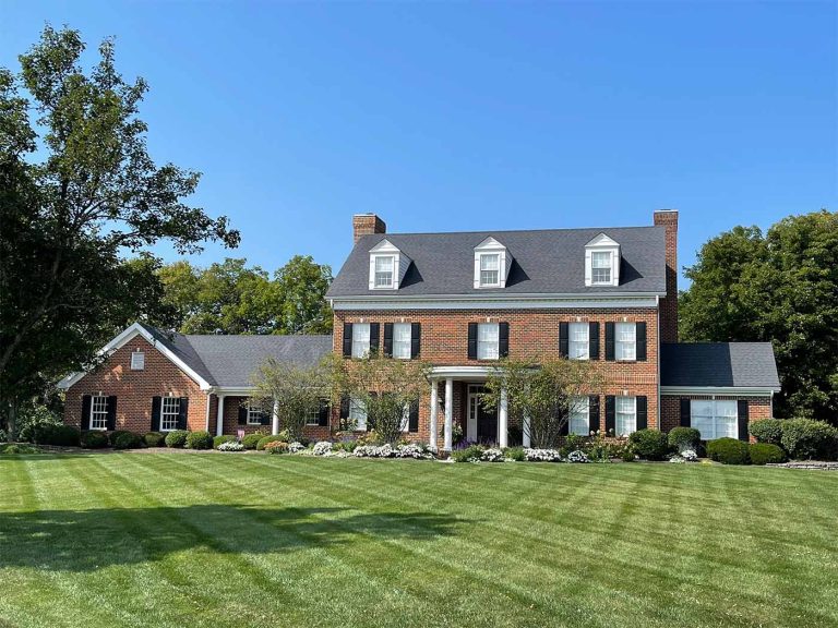 Georgian style home with 6-inch white gutters and diamondback mesh gutter guards