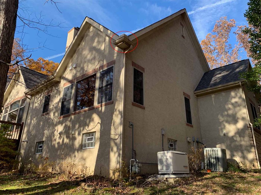 a roof valley that meets a small section of 5-inch gutter at an outside corner. the water flow overwhelmed the gutter and caused extensive wood damage to the cedar fascia and subfascia boards