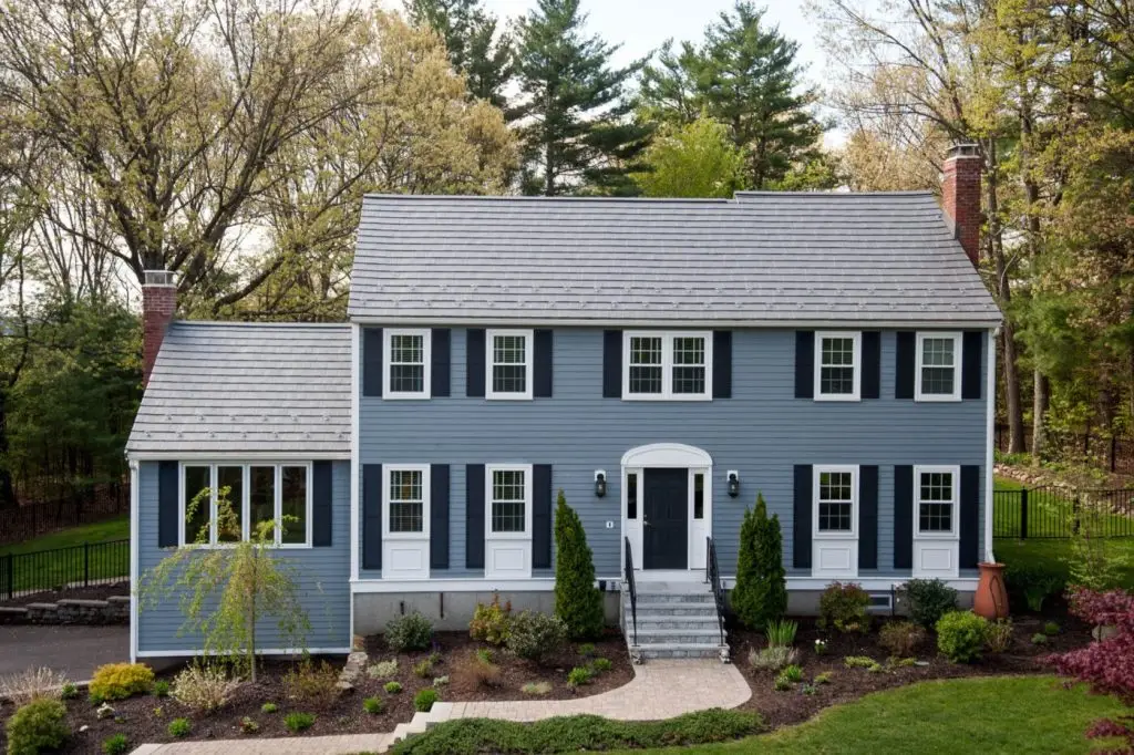 grey sided colonial home with metal shingles and snow guards installed on the roof